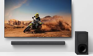 Soundbar under en TV-skärm som visar en motorcyklist i en öken