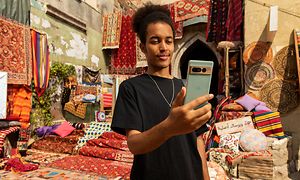 Man som står på en marockansk mattmarknad och tittar på sin Google Pixel 7 Pro