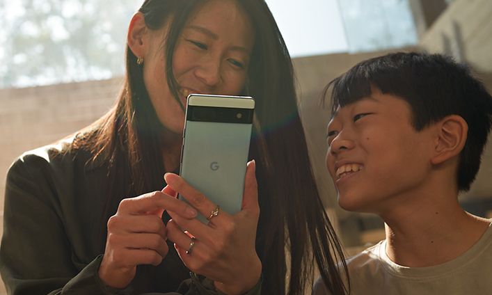 Kvinna och barn tittar på en Pixel 6a