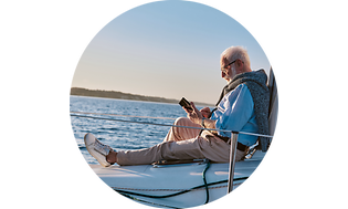 CS-Tablet and laptop insurance-Man sitting on a boat checking phone