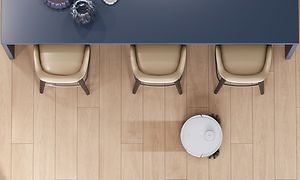 N8 PRO rengör ett ljust trägolv vid ett bord med stolar