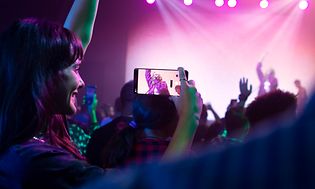 Woman at a concert filming a singer on her Google Pixel 7 Pro