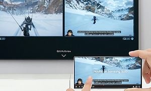 Samsung Neo QLED gaming-TV som visar MultiView med ett spel på skärmen och en spel-walkthough på en mobilskärm