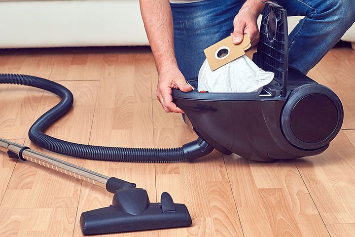 Man som byter dammsugarpåse i en dammsugare