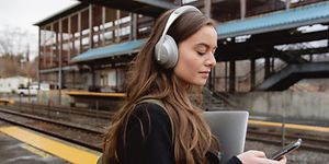 Woman with headphones on train station