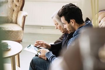 Man and old woman looking at a tablet