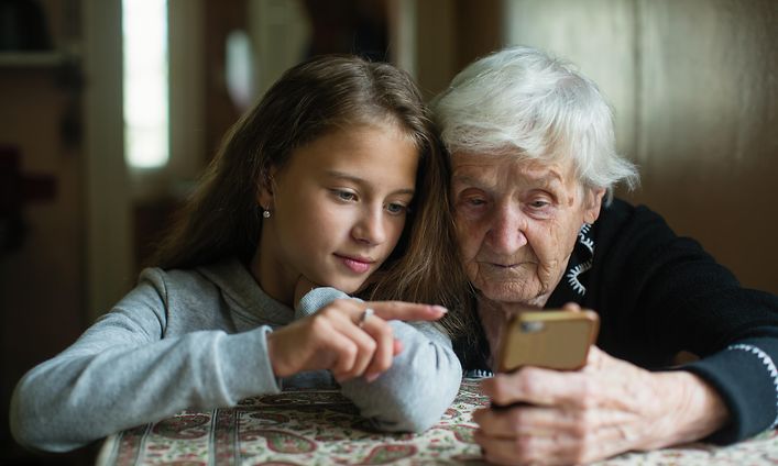 Old woman and young girl looking at a smartphone