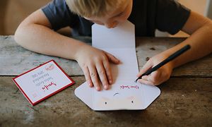 Liten pojke skriver önskelista till jul