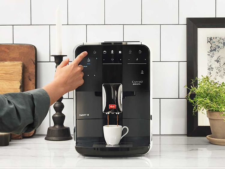 En kvinna som använder Melitta Barista T espressomaskin