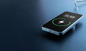 Smartphone laddning: En iPhone laddar batteriet från trådlös smart laddare.