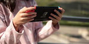 Tjej som spelar Nintendo Switch-konsol.