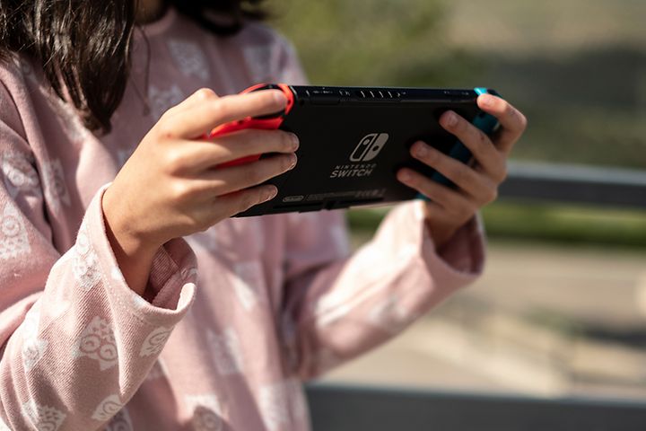 Tjej som spelar Nintendo Switch-konsol.