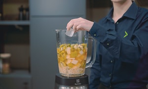 SDA - Blender - A woman adding ice to a filled blender