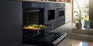 Bosch Accent line ugn med öppen lucka och en bakplåt med grönsaker