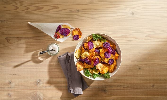 Grönsakschips i en skål på ett bord