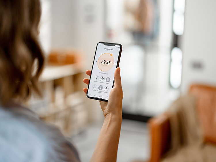 Inomhusklimat: Kvinna som mäter luftkvaliteten med en app.