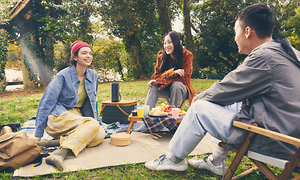 People in park with portable speaker un the middle