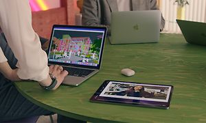 Grönt bord med MacBooks, iPads och Airpods