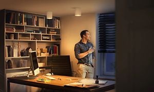Smart belysning - hjemmet - mand der står på et oplyst kontor med en kop i hånden