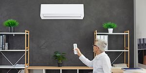 Man at home office turning on a fan