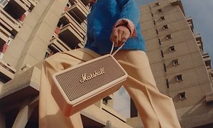 Man som går med en Marshall-högtalare
