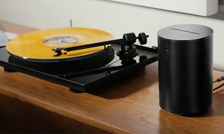 Sonos Era 100 bredvid en vinylspelare