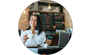 Woman with phone and laptop at cafe