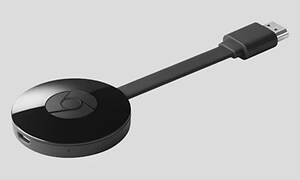 En rund svart dosa, chromecast enhet i svart med en anslutande kabel. 