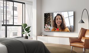 QLED770  TV wall mounted in living room with Google Duo in use