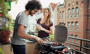 couple grilling on balcony