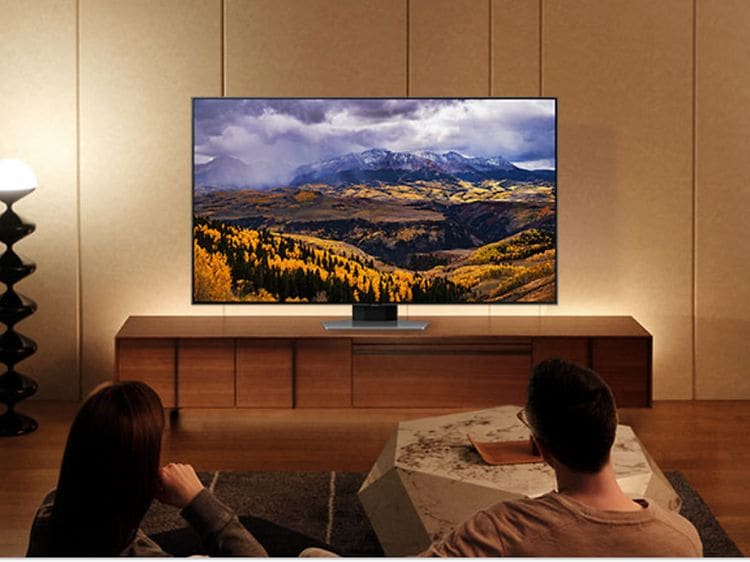 Ett par som sitter i en soffa och tittar på en Samsung TV