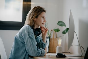 woman with headphones in front of PC