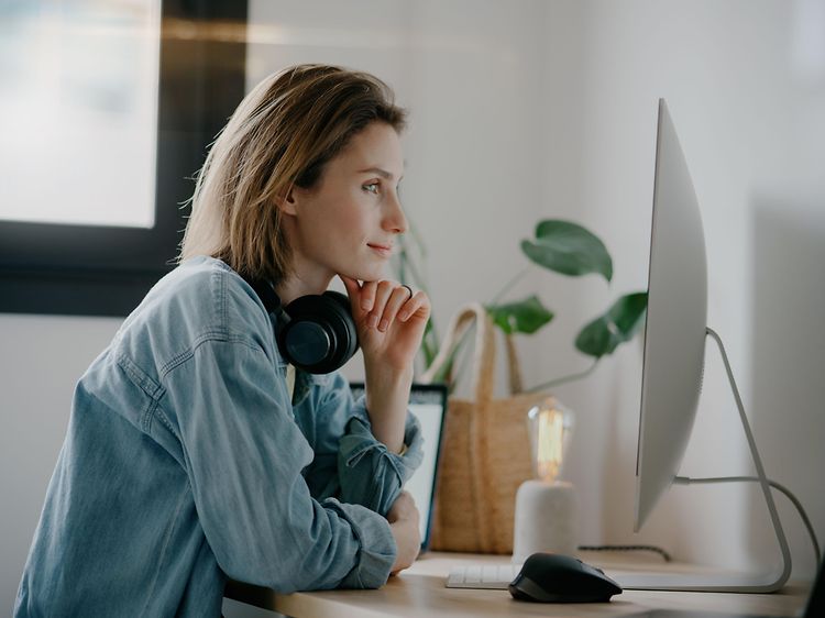 woman with headphones in front of PC