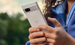 Kvinna som håller en Google Pixel 7a i regnet