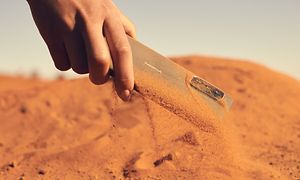 Dammtät Nokia XR21-telefon som plockas upp från sand
