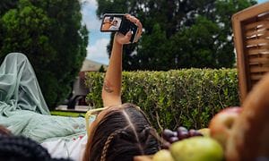 Kvinna håller Motorola Razr-telefon och tar en selfie