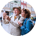 Äldre par som står på gatan i ett stad och tar en selfie med mobilen