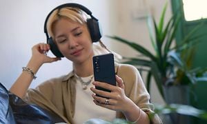 Ung tjej lyssnar på musik på Xperia 1 V med hörlurar