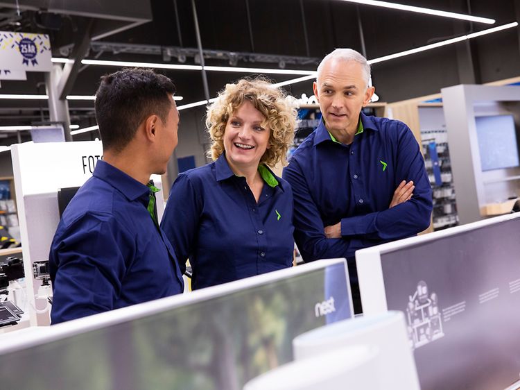 Three uniformed Elkjøp employees in an Elkjøp store