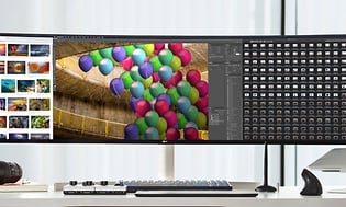 En UltraWide extra bred skärm med färglada bilder i fotoprogram