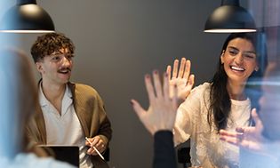 B2B - People high fiving at a meeting