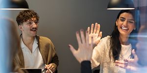 B2B - People high fiving at a meeting