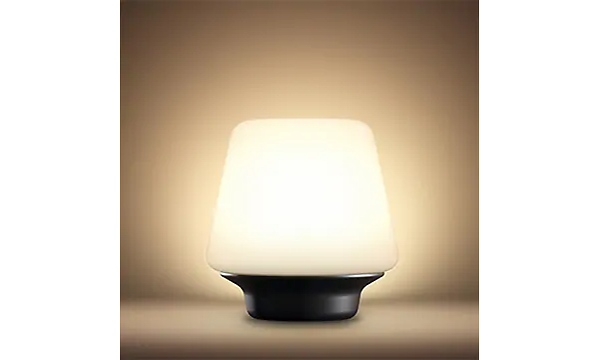 Philips Hue bordslampa med gult ljus. 