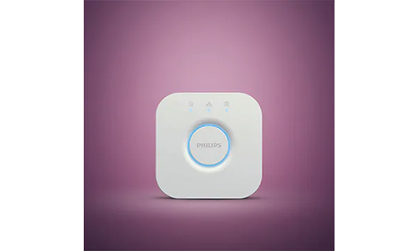 En vit kontrollpanel med en blått ljus runt knappen i mitten, några små symboler syns längst upp. Rosa bakgrund. 