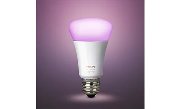 Vit Philips Hue glödlampa med rosa ljus, lila bakgrund. 