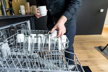 B2B - How to choose dishwasher for the workplace kitchen - Man empyting a dishwasher at work