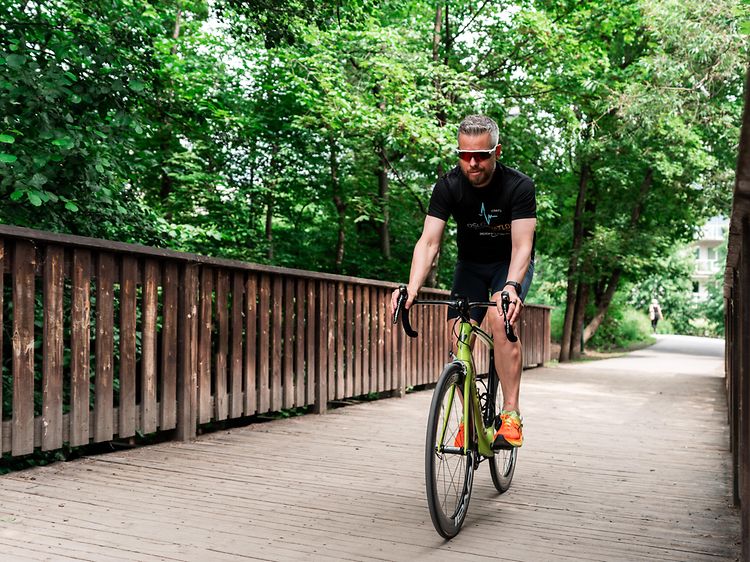 man riding race bike with sports watch