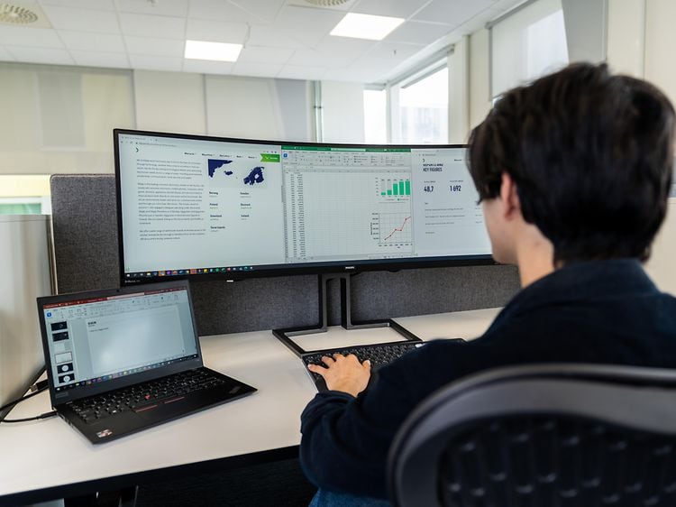 B2B - Computing - Bigger monitor - Office employee working with ultra-wide screen