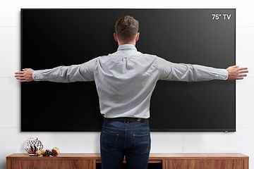 Samsung 75” TV som mäts av en man