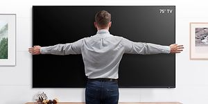 Samsung 75” TV som mäts av en man
